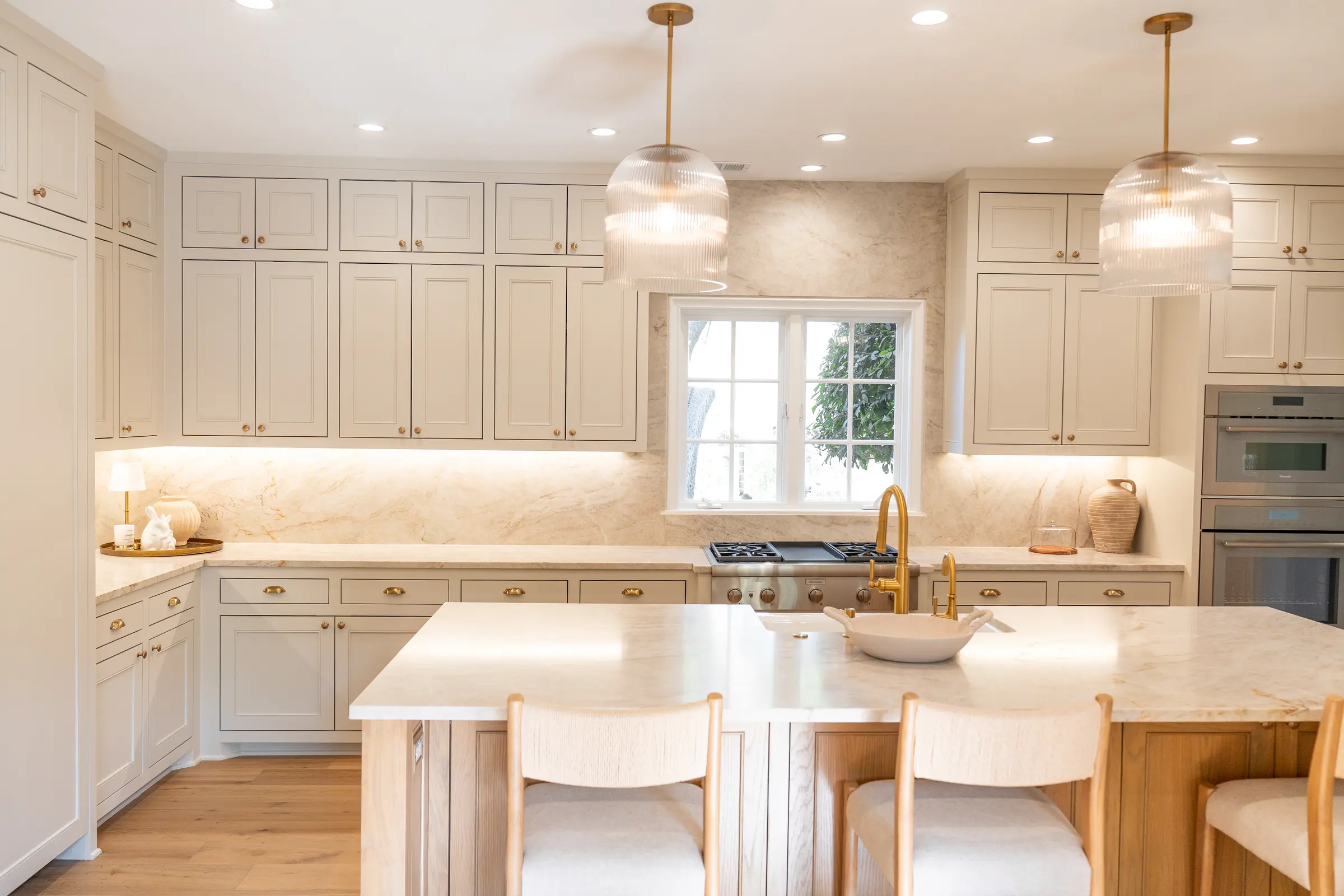 Creekline kitchen with a marble island and glass pendants