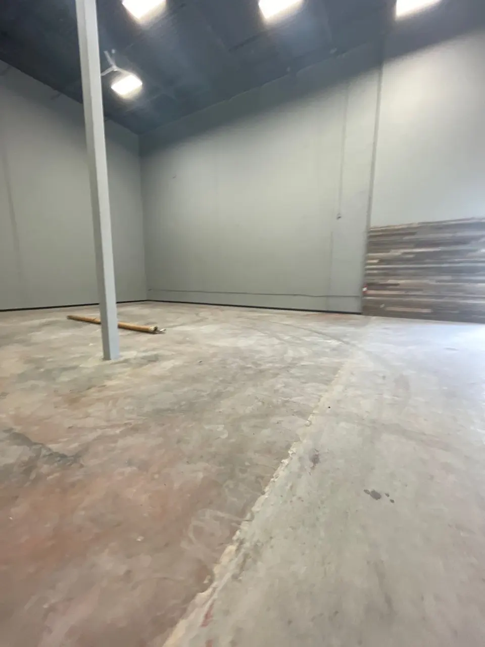 The tenant space before work started: bare slab, exposed deck and unfinished walls